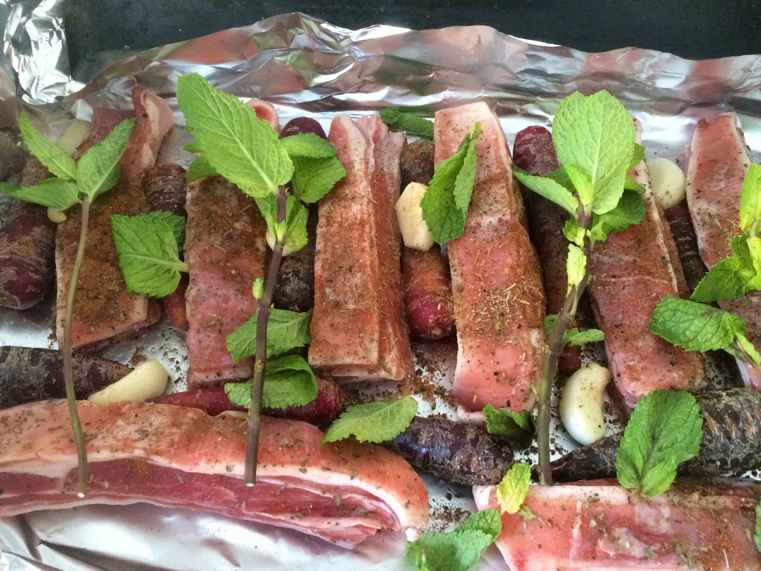 Uncooked lamb ribs with seasoning in aluminium foil.